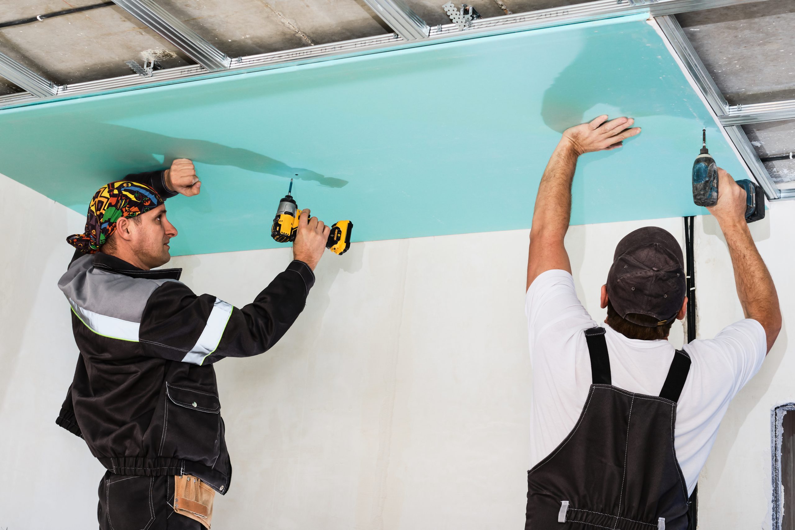 Plasterboard installers. Men assembling a drywall false ceiling.Simple and affordable renovation of premises drywall installation tape